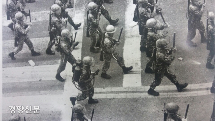 5·18당시 진압봉을 들고 소총을 소지한 채 광주 도심을 행진하는 공수부대원들.  화염방사기를 등에 짊어진 공수부대원이 보인다. │5·18기념재단 제공.