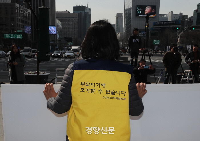 천막 철거가 시작된 광화문광장에서 세월호 참사 희생자 유가족이 손팻말을 들고 진상규명과 책임자 처벌을 촉구하고 있다.