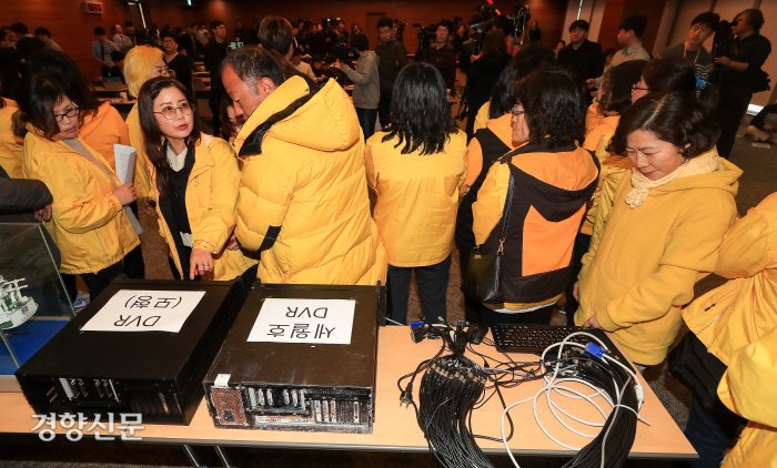 28일 서울 중구 포스트타워에서 세월호 유족들이 해군이 선내에서 수거했다고 주장한 DVR 모형과 검찰에 증거로 제출된 DVR을 살피고 있다. 우철훈 선임기자 photowoo@kyunghyang.com