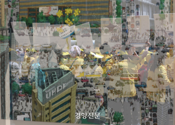 기억공간에 전시된 그림액자에 반사된 4.16세월호참사 가족협의회 가족과 시민들.  /강윤중 기자