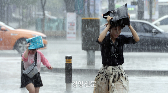 갑작스럽게 쏟아지는 소나기를 피해 시민들이 뛰어가고 있다.        서성일 기자 centing@kyunghyang.com