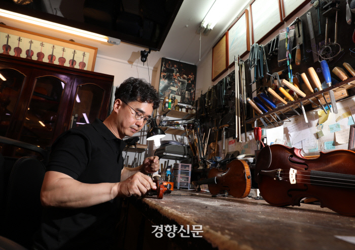 아버지에 이어 2대째 현악기 수리 전문 매장 ‘한양악기’를 운영하는 최신해씨(46)가 ‘악기 나눔’ 행사에 재능기부로 참여해 시민이 기증한 바이올린을 수리하고 있다. 최씨는 악기 수리와 제작을 공부하기 위해 영국 유학을 하고 돌아왔다. /강윤중 기자