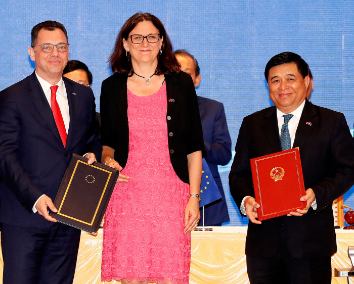 응우옌 치 둥 베트남 계획·투자장관(오른쪽)과 세실리아 말름스트룀 유럽연합(EU) 통상담당 집행위원(가운데)이 지난달 30일 하노이에서 베트남·EU 자유무역협정과 투자촉진협정에 서명한 뒤 협정문을 들고 기념촬영을 하고 있다. 하노이 | EPA연합뉴스