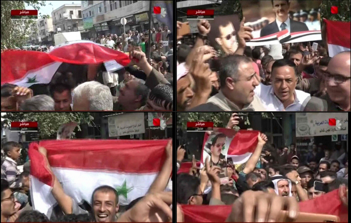 시리아 국영방송이 전한 15일 북부 도시 만비즈의 모습. 반정부군, 이슬람국가(IS), 쿠르드민병대에 차례로 장악됐던 이 도시에 2012년 이후 처음으로 정부군이 입성하자 주민들이 시리아 국기와 바샤르 알아사드 대통령의 사진을 들고 환영하는 장면이다.  시리아TV·AFP연합뉴스