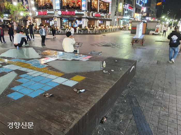 지난 22일 경기 수원시 팔달구 인계동 ‘나혜석 거리’에 설치된 무대 위와 바닥에 음료수 캔과 담배꽁초 등이 버려져 있다.