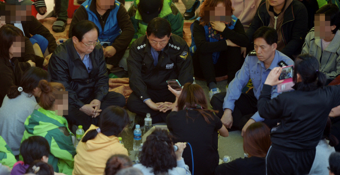 이주영 당시 해양수산부 장관, 김석균 해양경찰청장, 최상환 해양경찰청 차장(왼쪽부터)이 2014년 4월24일 전남 진도 팽목항 가족 대책본부에서 유족과 취재진에게 둘러싸여 있다.  경향신문 자료사진