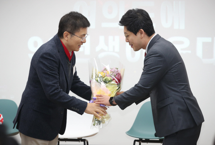 ‘정치평론’ 김병민은 야당행 자유한국당 황교안 대표가 19일 여의도 당사에서 열린 김병민 경희대 객원교수(오른쪽) 영입 환영식에서 꽃다발을 전해주고 있다.  연합뉴스