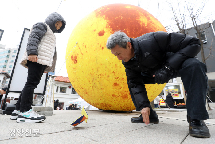 돈의문박물관마을에서 손자와 딱지치기를 하는 할아버지. / 권도현 기자