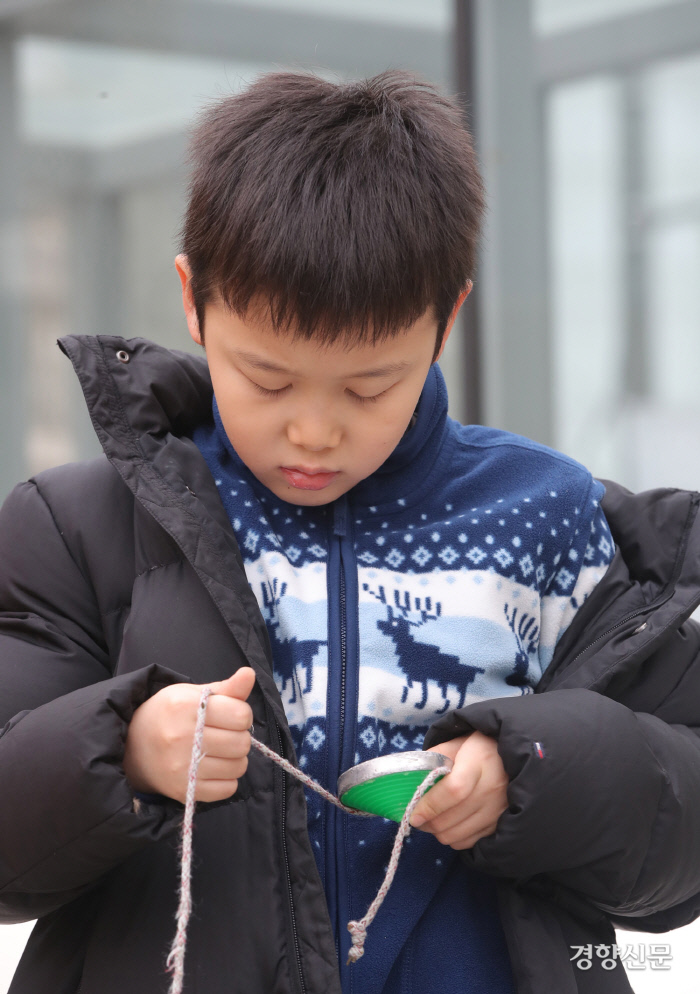 한 어린이가 팽이에 줄을 묶고 있다. 한참동안 줄을 묶어봤지만, 결국 팽이 돌리기에 실패했다. / 권도현 기자