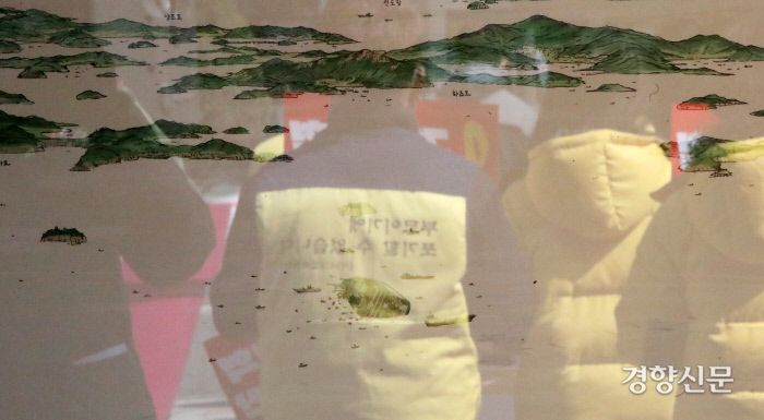 광화문광장 세월호 기억공간에 전시된 그림에 기자회견에 참석한 유가족들의 모습이 비치고 있다. / 권도현 기자 lightroad@kyunghyang.com