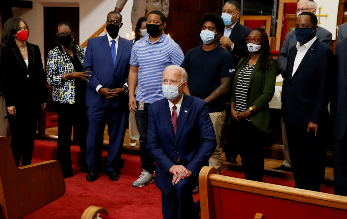 바이든, 흑인 인사들 만나 ‘무릎꿇기’ 미국 민주당 대선후보로 사실상 확정된 조 바이든 전 부통령(가운데)이 1일(현지시간) 델라웨어주 윌밍턴의 한 교회를 찾아 인종차별에 항의하는 제스처인 무릎꿇기 자세를 취하고 있다. 흑인 남성 조지 플로이드의 사망으로 미 전역에서 일주일째 시위가 이어지고 있는 가운데 바이든 전 부통령은 윌밍턴의 시위현장을 방문한 뒤 지역 흑인 정치인·종교인과 만나 이야기를 나눴다. 윌밍턴 | 로이터연합뉴스