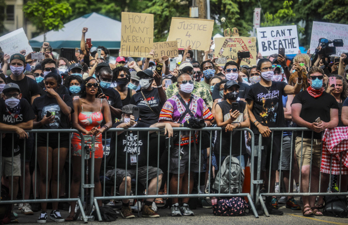 미국 미네소타주 미니애폴리스 노스센트럴대학교에서 4일(현지시간) ‘조지 플로이드’ 추모식이 열린 후 시민들이 플로이드의 시신이 안장된 관이 영구차로 옮겨지는 것을 지켜보고 있다. 미니애폴리스|AP연합뉴스