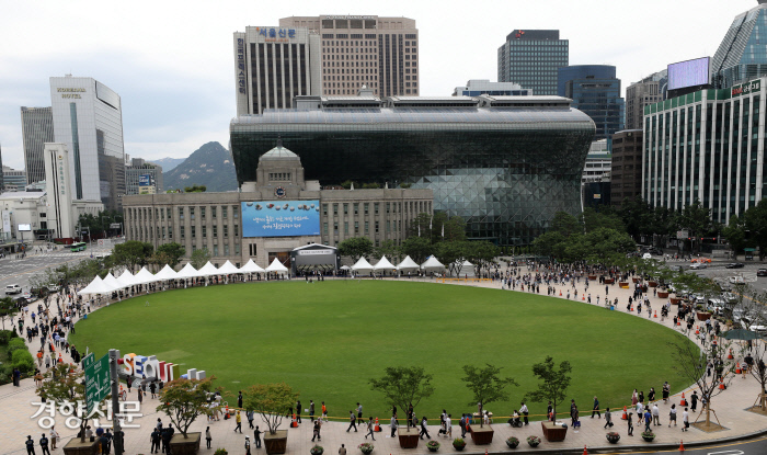 12일 서울광장에 마련된 고 박원순 서울시장 시민분향소를 찾은 시민들이 잔디 광장을 한바퀴 도는 줄을 서서 순서를 기다리며 조문하고 있다. / 김창길 기자