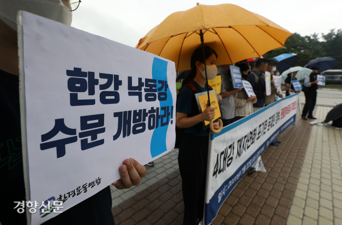 4대강재자연화시민위원회원들이 4대강 재자연화를 촉구하는 내용이 적힌 손팻말을 들고 있다.. / 권도현 기자