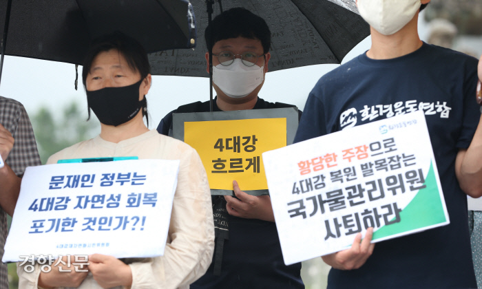 기자회견에서 한 참석자가 ‘4대강 흐르게’라고 적힌 손팻말을 들고 있다. / 권도현 기자