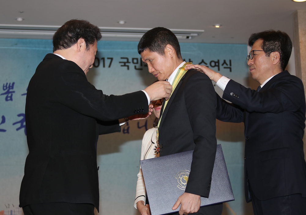 이낙연 국무총리가 31일 오후 서울 세종로 정부서울청사에서 열린 국민추천포상 수여식에서 세월호 사고현장에서 소방호스로 수십 명의 목숨을 살린 ‘파란 바지의 의인’ 김동수(54)씨에게 국민훈장 동백장을 주고 있다. 2018.1.31 연합뉴스