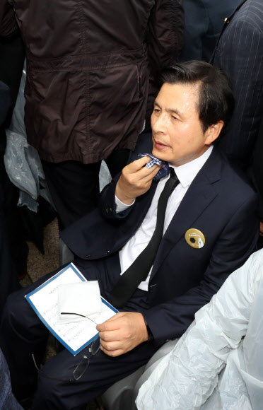 얼굴 닦는 황교안 대표 - 자유한국당 황교안 대표가 18일 오전 광주 북구 국립 5.18민주묘지에서 열린 제39주년 5.18민주화운동 기념식에 시민들의 항의를 받으며 참석한 뒤 땀을 닦고 있다. 2019.5.18 연합뉴스