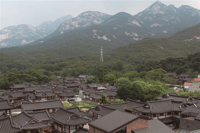 은평역사한옥박물관 옥상에서 바라본 북한산 자락과 한옥마을의 경관. 온돌 때문에 단층으로만 지었던 한옥을 현대적으로 진화시켜 이층으로 지은 게 특징이다. 한옥마을에는 한옥박물관과 맹꽁이 서식 습지 등이 공존한다.