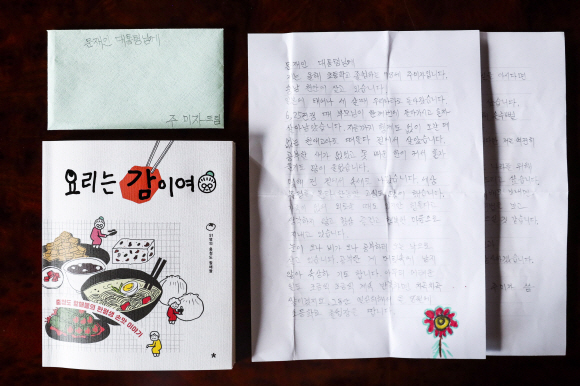 문재인 대통령이 지난 8일 충청도 할머니들로부터 선물 받은 책 ‘요리는 감이여’.이 책은 학교를 다니지 않아 글을 모르고 사시다가, 충청남도 교육청 평생교육원에서 초등학교 과정을 이수한 51명의 할머니들이 자신의 손맛을 소개한 요리책이다. 2019.08.12 청와대제공