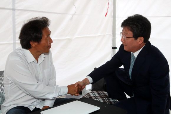 바른미래당 유승민(오른쪽) 의원이 2일 조국 법무부 장관 사퇴를 요구하며 국회 본청 앞 계단에서 18일째 단식농성 중인 자유한국당 이학재 의원을 방문해 격려하고 있다.연합뉴스