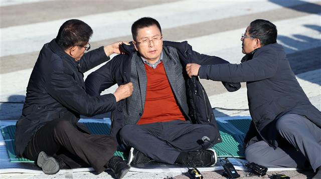 ‘단식 농성’ 도움 받아 외투 입는 황교안 대표 - 황교안 자유한국당 대표가 20일 오후 서울 종로구 청와대 사랑채 인근에서 단식농성을 벌이고 있다. 2019.11.20 뉴스1