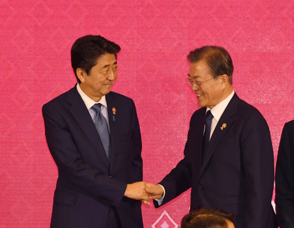 문재인 대통령이 지난 11월 4일(현지시간) 태국 방콕 임팩트 포럼에서 열린 역내 포괄적 경제동반자협정(RCEP) 정상회의에 참석자들과 기념촬영에 앞서 아베 일본 총리와 악수 하고 있다.서울신문DB