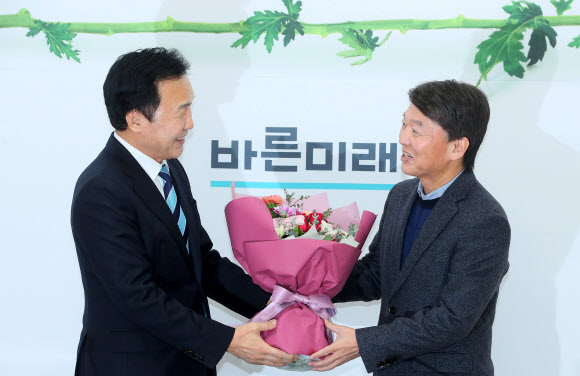 안철수에게 꽃다발 선물하는 손학규 - 바른미래당 손학규 대표가 27일 국회에서 안철수 전 대표에게 꽃다발을 선물하고 있다. 2020.1.27 연합뉴스