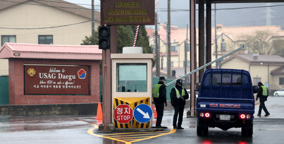 대구 미군기지, 출입 절차 강화  - 25일 대구의 캠프워커 미군기지 출입문에서 부대 관계자들이 차량 출입을 통제하고 있다. 미군은 대구에 사는 주한미군 가족이 코로나19 확진 판정을 받으면서 위험 단계를 격상하고 기지 출입 절차를 강화했다.대구 연합뉴스