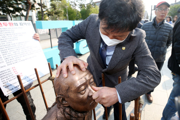 옛 전남도청 앞에 설치되는 ’전두환 치욕 동상’ - 25일 오후 광주 동구 5·18민주광장에에 ’전두환 치욕 동상’이 설치돼 한 시민이 동상의 코를 꼬집고 있다. 5·18단체는 오는 27일 전씨가 사자 명예훼손 재판을 받기 위해 출석하는 광주지법 앞에 이 동상을 설치해 엄중한 처벌을 촉구할 예정이다. 2020.4.25 연합뉴스