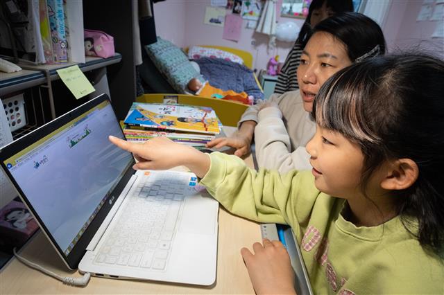 ‘엄마, e학습터 언제 접속돼?’ - 신종 코로나바이러스 감염증(코로나19) 확산으로 ‘온라인 개학’ 중인 20일 서울시내 한 가정에서 초등학교 3학년 학생이 엄마와 함께 e학습터 접속을 기다리고 있다. 이날 초등 1∼3학년 137만여명이 3차 온라인 개학을 시작해 전국 초·중·고교생 535만명이 모두 원격수업을 받게 됐다. 2020.4.20 뉴스1