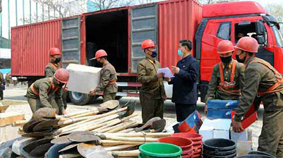 마스크 쓴 북한 건설 노동자들 - 평양종합병원 건설장에 각지에서 보낸 지원물자가 쇄도하고 있다고 21일 노동당 기관지 노동신문이 1면에 보도했다. 사진은 지원물자를 나르는 건설 노동자들이 마스크를 착용한 모습. 2020.4.21 노동신문 홈페이지 캡처=연합뉴스