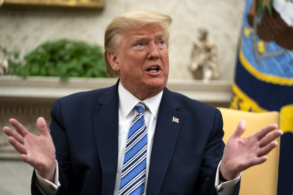 도널드 트럼프 미국 대통령이 28일(현지시간) 백악관 집무실에서 론 디샌티스 플로리다주 지사를 면담하던 도중 취재진과 일문일답을 나누는 과정에 요란한 손동작을 써가며 발언하고 있다.워싱턴 AP 연합뉴스