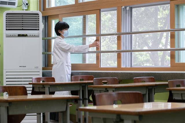 개학 앞두고 ‘에어컨 점검 및 교실 환기’ - 고등학교 개학을 시작으로 순차적 등교를 앞둔 7일 오후 서울 성동구 무학여자고등학교에서 한 교사가 에어컨 가동 점검 및 교실 환기를 하고 있다. 2020.5.7 뉴스1