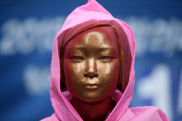 ‘후원금 회계 논란’의 진실은? - 정의기억연대 출신 더불어시민당 윤미향 당선인의 ‘후원금 회계 논란’이 붉어지고 있는 가운데 비가 내린 15일 서울 종로구 옛 일본대사관 앞에 설치된 평화의 소녀상에 우비가 입혀져 있다. 2020.5.15 연합뉴스