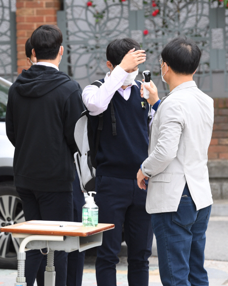 코로나 19 여파로 미뤄졌던 고등학교 3학년 등교일인 20일 서울의 한 고등학교에서 3학년 학생들이 교실 입실 전 체온을 측정하고 있다. 2020.5.20 오장환 기자 5zzang@seoul.co.kr
