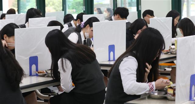 고등학교 3학년 학생들의 등교 개학이 시작된 20일 울산 중구 함월고등학교에서 학생들이 칸막이가 설치된 급식실에서 점심을 먹고 있다. 2020.5.20뉴스1