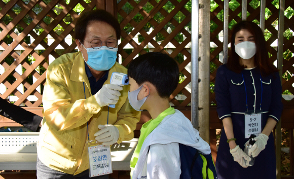 고등학교 2학년과 중학교 3학년, 초등학교 1∼2학년, 유치원생들이 등교 수업을 시작한 27일 오전 서울 송파구 세륜초등학교에서 조희연 교육감이 학생들의 열체크를 하고 있다.2020.5.27.  이종원 선임기자 jongwon@seoul.co.kr