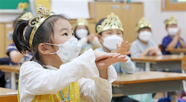 초등 1학년, 두 달 기다린 첫 등교… “반짝반짝 왕관 쓰고 손 씻어요” - 27일 경기 수원시 팔달구 매여울초등학교 1학년 교실에서 어린이들이 입학을 축하하는 뜻으로 마련된 왕관을 쓰고 손 씻기 교육을 받고 있다. 코로나19 일일 신규 확진자가 40명을 기록한 이날 불안과 설렘 속에 2차 등교 개학이 시작됐다. 고등학교 2학년, 중학교 3학년, 초등학교 1∼2학년, 유치원생 237만명이 학교에 나왔다. 코로나19 교내 감염을 우려하는 목소리가 높지만 교육 당국은 원격수업만으로는 충분한 교육을 제공할 수 없다며 등교수업의 필요성을 강조했다.뉴스1