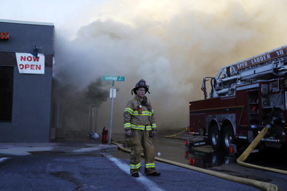 28일(현지시간) 미국 세인트폴에서 한 소방관이 방화로 불타는 상점 앞에서 서 있다. AP통신