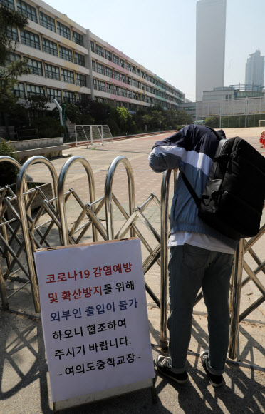 등교 중단한 여의도 - 29일 오전 여의도중학교에서 관계자가 학교 정문으로 들어가고 있다. 이 학교는 여의도 학원강사와 수강생 코로나19 확진으로 이날 예정된 학생 등교를 온라인 수업으로 변경했다. 2020.5.29 연합뉴스