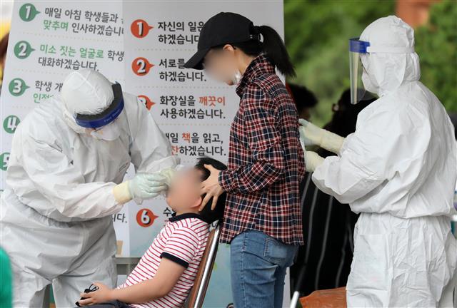 안양 코로나19 확진자 발생으로 긴급 전수조사 실시 - 31일 오후 경기도 안양시 만안구 양지초등학교에 마련된 선별진료소에서 학생들과 학부모들이 신종 코로나바이러스 감염증 (코로나19) 검사를 받고 있다. 최근 제주 여행을 다녀온 경기 안양?군포 소재 교회 신도?관계자 등 9명이 코로나19 확진 판정을 받았으며 이 중 5명은 만안구 소재 A교회 신도 가족으로 관내 양지초등학교 학생도 포함된 것으로 확인됐다. 2020.5.31/뉴스1