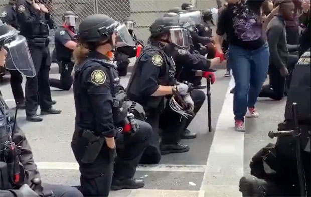 1일 오리건주 포틀랜드 지방법원 앞 시위 현장에서 플로이드를 추모하는 의미로 무릎을 꿇은 경찰의 모습./사진=트위터