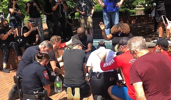 (위)조지 플로이드 사망을 추모하고 인종차별을 반대하는 시위에서 경찰을 포함한 백인들이 캐리 지역 교회의 지도자인 페이스 목사 부부의 발을 씻어주고 있다. (아래)발을 씻어주는 의식을 마친 뒤 함께 기도하는 모습.