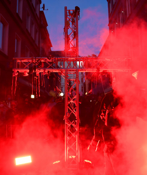 코로나19가 확산되고 있는 가운데 11일(현지시간) 독일 함부르크의 리퍼반 홍등가에서 성매매 업소 영업 재개를 요구하는 성매매 여성들의 집회 도중 속옷으로 덮인 십자가가 점등되고 있다.로이터 연합뉴스