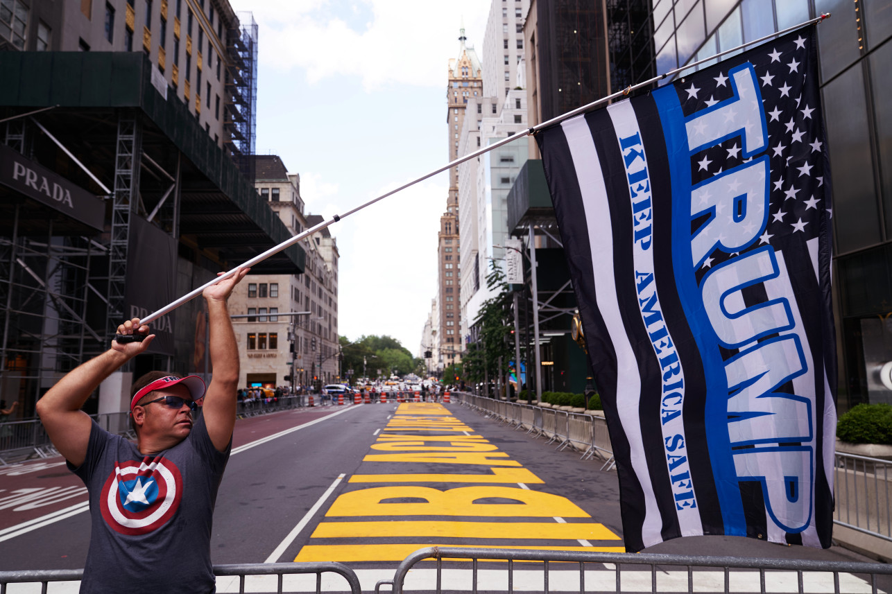 뉴욕 맨해튼 트럼프 타워 앞 도로에 그려진 ‘흑인 생명도 소중하다’(Black lives Matter) 문구 앞에 선 트럼프 지지자들