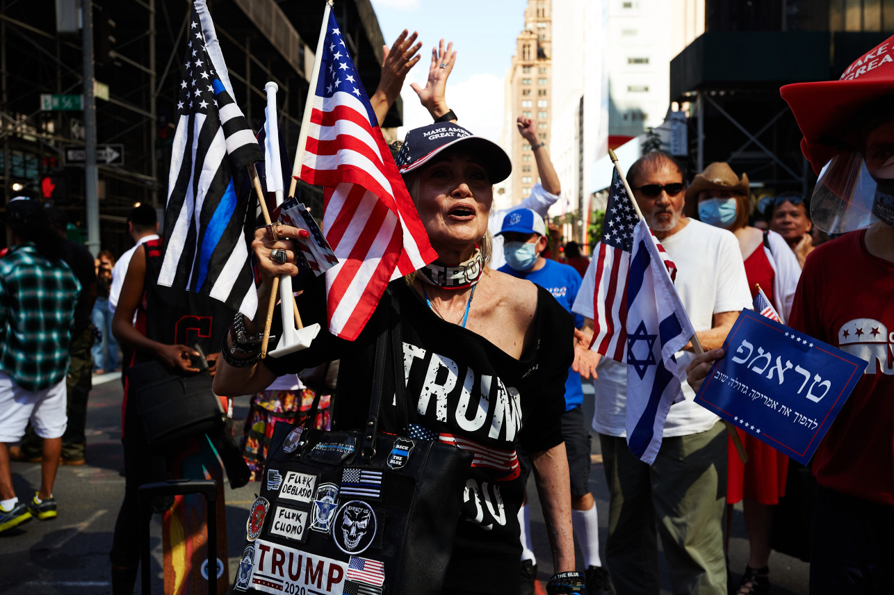 뉴욕 맨해튼 트럼프 타워 앞 도로에 그려진 ‘흑인 생명도 소중하다’(Black lives Matter) 문구 앞에 선 트럼프 지지자들