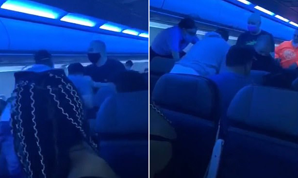 두 남성이 문제의 남성을 제압하고 또 다른 남성과 승무원이 지원하고 있는 모습.