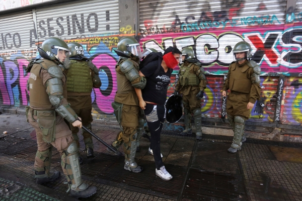 (사진출처=EPA/ELVIS GONZALEZ/연합뉴스)경찰에 구속된 시위자Policemen arrest a demonstrator during a protest against President Sebastian Piñera, at the Plaza Italia in Santiago, Chile, 20 March 2020. Plaza Italia, ground zero of the protests in Chile, was fenced off and almost empty this Friday due to the coronavirus situation, an unprecedented image in the last five months. Only a handful of young people roamed around a roundabout that since October has gathered thousands of people every week.