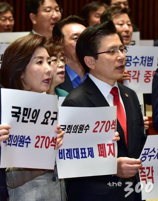 23일 오전 서울 여의도 국회 예결위회의장에서 열린 자유한국당 의원총회에서 황교안 대표, 나경원 원내대표 등 참석자들이 자당을 제외한 여야4당의 선거제 개편안 및 공수처 설치법안 등 신속처리안건 잠정합의를 규탄하는 내용의 손팻말을 들고 구호를 외치고 있다./사진=이동훈 기자