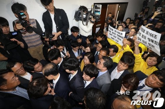 26일 오후 서울 여의도 국회 정치개혁 특별위원회 전체회의장 앞에서 자유한국당 의원 및 당직자들이 공직선거법 개정안 신속처리안건(패스트트랙) 지정동의의 건 통과를 막기 위해 입구를 막아서자 정의당, 민주당 의원 및 당직자들이 '국회법 제166조(국회 회의 방해죄) 징역 5년 또는 징역 7년'이라고 쓰인 손팻말을 들고 있다. / 사진제공=뉴스1